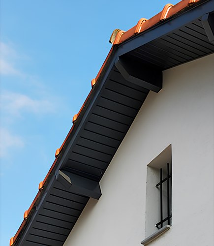 Habillage de rive anthracite contrastant avec une façade blanche